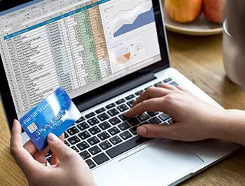 A person putting is bank card details on his computer
